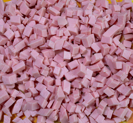 Boiled sausage cut into cubes, close-up. Natural food cooking background, ingredient top viewの写真素材