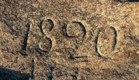 The inscription of the year 1820 embossed on the surface of a granite stoneの写真素材
