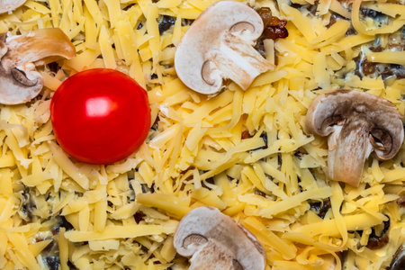 Quiche tart in the process of cooking close-up. Sliced mushrooms, yellow grated cheese and cherry tomatoの写真素材