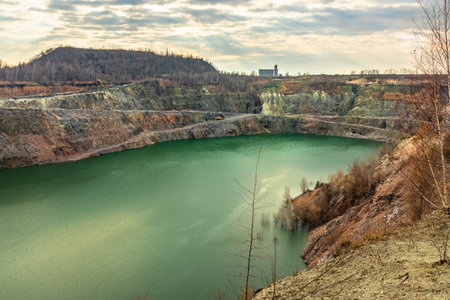 Open pit mining in Ukraine. Granite quarry with a lake in Kremenchuk city. Surface mining - soil and rock overlying the mineral deposit (the overburden) are removedの写真素材