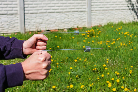 Dowsing rod metal indicator in the hands of a man. Modern Divining L rods cylinder resonator for esoteric practices. An ancient method unproven by scienceの写真素材