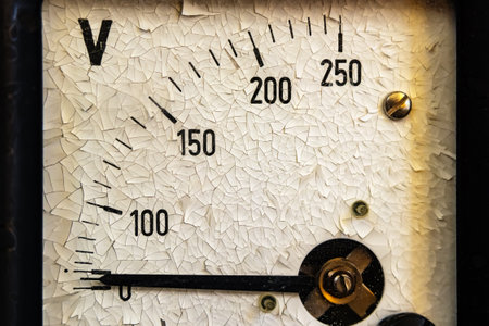 Old voltmeter, measuring device close-up. Paint is cracked on the analog scaleの写真素材