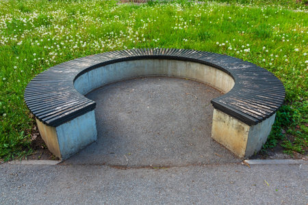 Round bench near the alley and asphalt path. Park circular bench and green grassの写真素材