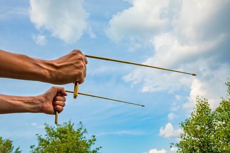 Dowsing with metal L rods in hands - a modern dowser's tool. Two dowsing rods for practicing radiesthesia. An ancient method, not proven by scienceの写真素材