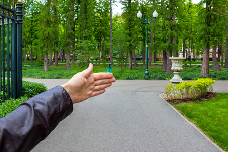 A woman's hand indicates the direction along an alley in a public city park. The girl helps the tourist who asks directlyの写真素材