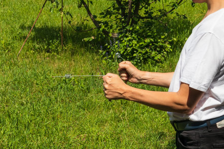 A dowser with metal L-shaped rods in his hands is a modern dowser's tool. Radiesthesia practices - an ancient method not proven by scienceの写真素材