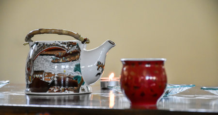 Preparation of chinese tea - table set with a kettle, cups, candles, and some green and black tea...