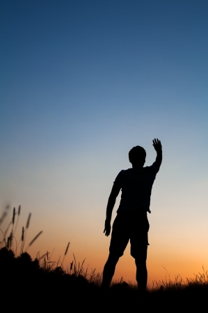Silhouette of man standing in fieldの写真素材