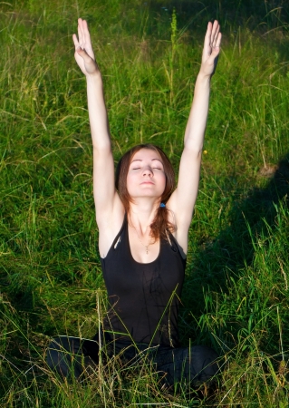 Beautiful girl stretching herself in fieldの写真素材