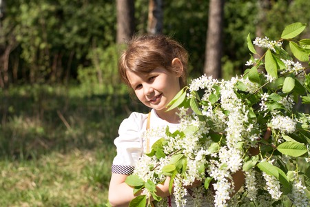 Girl smiling with a bouquet of cherry blossomsの写真素材