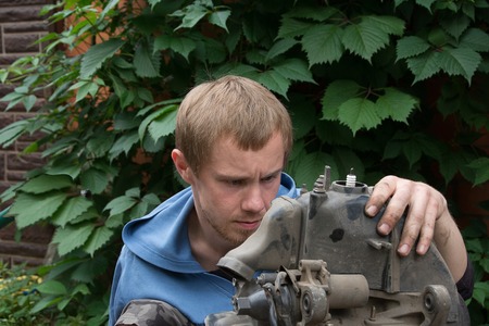 boy repairing a motor scooter on the street. Fault on the roadの写真素材