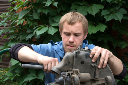 boy repairing a motor scooter on the street. Fault on the roadの写真素材