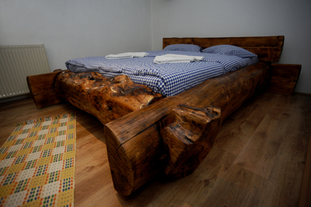 Old wooden rustic bed with blue sheetsの写真素材