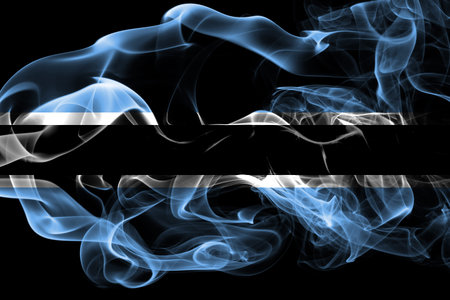 National flag of Botswana made from colored smoke isolated on black background. Abstract silky wave background.の写真素材