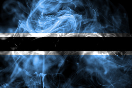 National flag of Botswana made from colored smoke isolated on black background. Abstract silky wave background.の写真素材