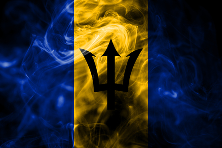 National flag of Barbados made from colored smoke isolated on black background. Abstract silky wave background.の写真素材