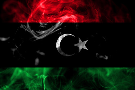 National flag of Libya made from colored smoke isolated on black background. Abstract silky wave background.の写真素材