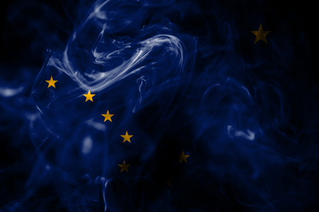 National flag of Alaska made from colored smoke isolated on black background. Abstract silky wave background.の写真素材