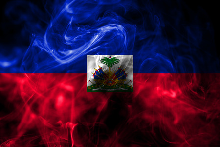 National flag of Haiti made from colored smoke isolated on black background. Abstract silky wave background.の写真素材