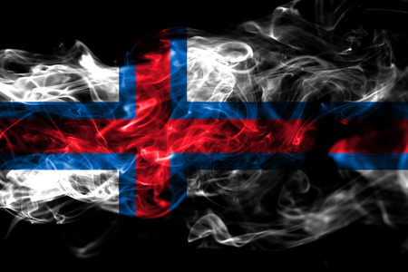 National flag of Faroe Islands made from colored smoke isolated on black background. Abstract silky wave backgroundの写真素材