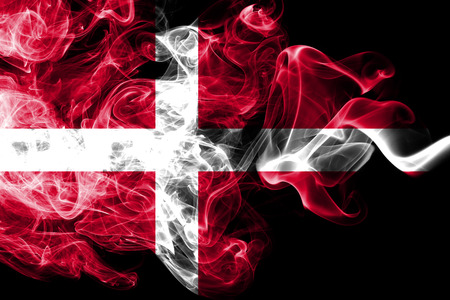 National flag of Denmark made from colored smoke isolated on black background. Abstract silky wave background.の写真素材
