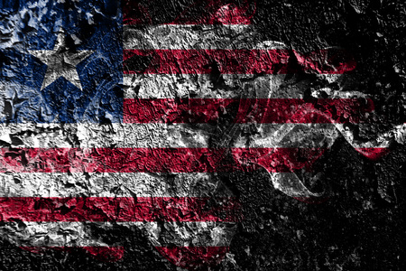 Liberia smoky mystical flag on the old dirty wall backgroundの写真素材