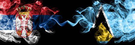 Serbia vs Saint Lucia smoky mystic flags placed side by side. Thick colored silky smokes combination of Serbian and Saint Lucia flagの写真素材