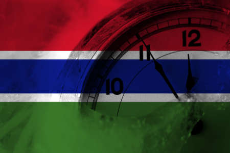 Gambia, Gambian flag with clock close to midnight in the background. Happy New Year conceptの写真素材