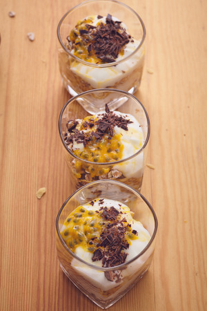 Close up food style on the wooden tabble, oats musli mixed with yogurt chocolate and passion fruit Close up food style on the wooden tabble, oats musli mixed with yogurt chocolate and passion fruit