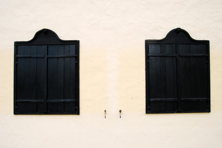 Old black wooden window shutters. Shutters closed by night and a hot day.の写真素材