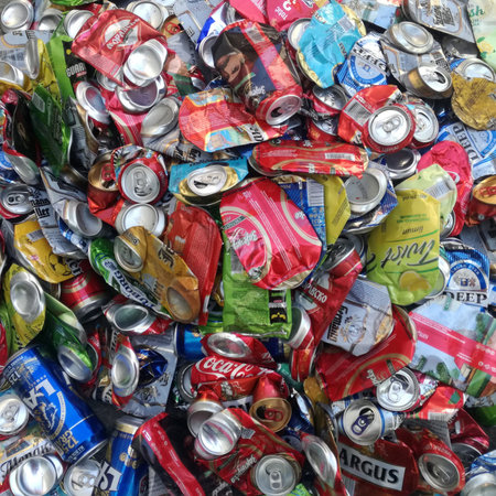 A pile of loose, smashed, crushed, empty, used aluminum beer and soda beverage cans at a scrap metal...