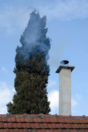 Smokey chimney in mid-winter on blue skyの写真素材