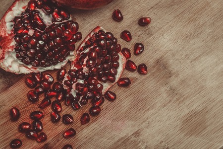 Chopped pomegranate on wooden board, narrow depth of fieldの写真素材