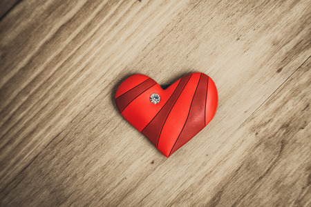 Red ornate herat on wooden table , look from aboveの写真素材