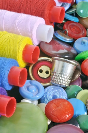 Spools of colored thread and a thimble on the buttons の写真素材