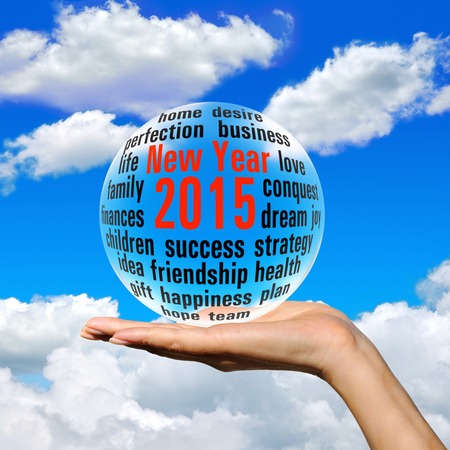 The magic ball on the palm against the blue sky and clouds. The collage on the theme of the New yearの写真素材