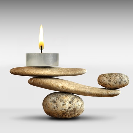 The balance of the lighted candle and stones in the pyramidの写真素材