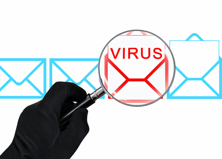 The concept of computer security. Hand with magnifying glass scans the emailの写真素材
