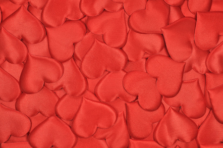A scattering of red souvenir hearts as an abstract backgroundの写真素材