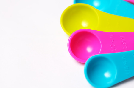 Kitchen colorful plastic measuring spoons on a white background. Close up view.の写真素材