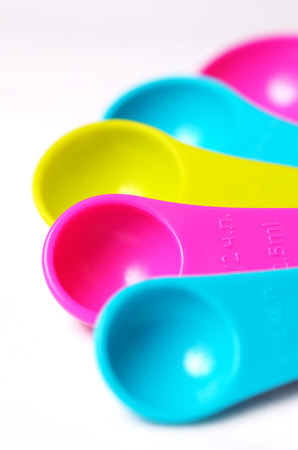 Kitchen colorful plastic measuring spoons on a white background. Close up view.の写真素材