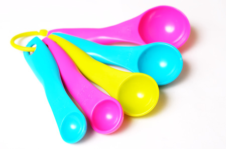 Kitchen colorful plastic measuring spoons on a white background. Close up view.の写真素材