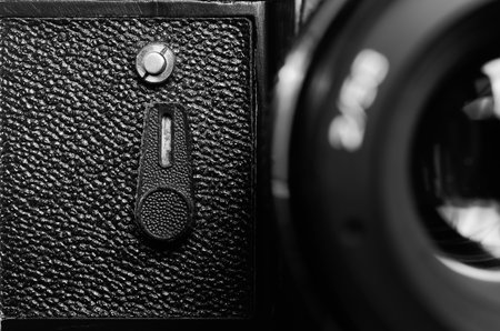 Fragment old film DSLR camera with lens. Lens and camera self-timer button. Front view. Macro....