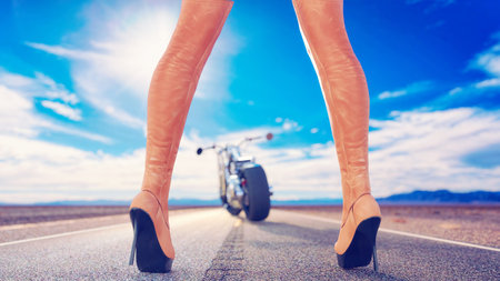 Female legs leather boots background of road, sky and bike.Desert road.Back view.Sexy pose.Girl...