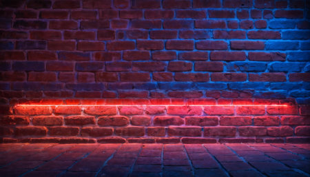 An empty brick wall is illuminated by neon lights with a gradient from pink to blue, creating a colorful and moody backdrop.の素材