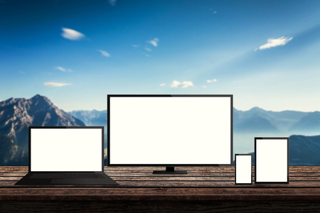 isolated responsive computer and mobile devices on desk with mountain nature background for mock up presentationの写真素材
