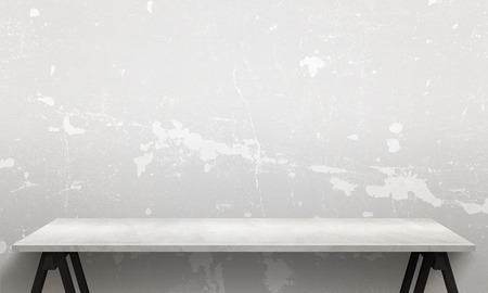 Modern white wooden table with legs and free space. Cracked white wall texture in background.の写真素材