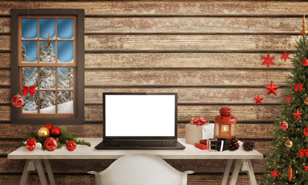 Black Santa laptop on table. Christmas tree, gifts, decorations in background.の写真素材