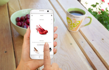 Online shopping with smart phone. Buying women shoes on online store.