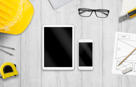 Tablet and smart phone on designer desk. Mockup for responsive web site promotion.の写真素材